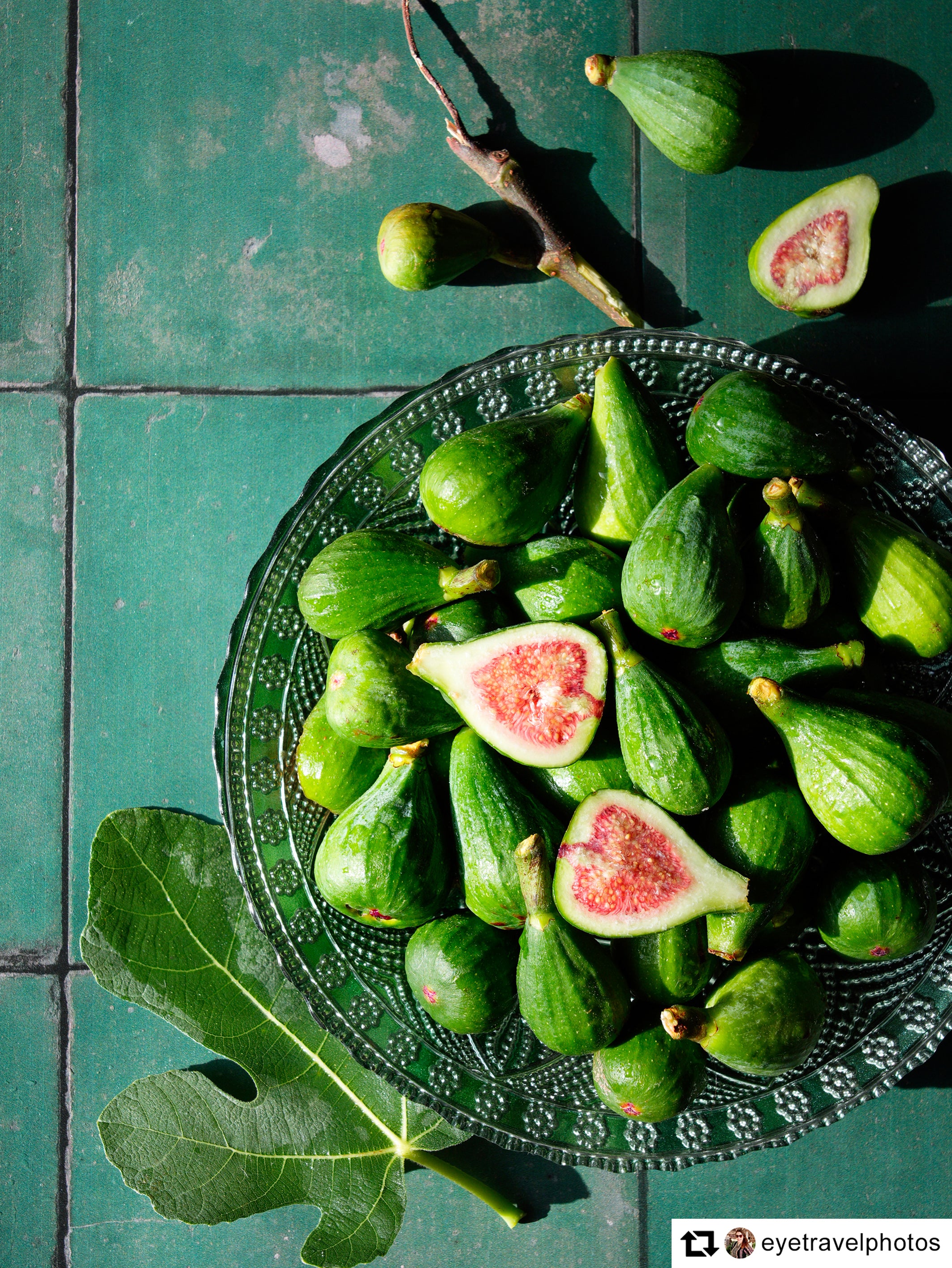 Image of light green unripe figs on green tile background