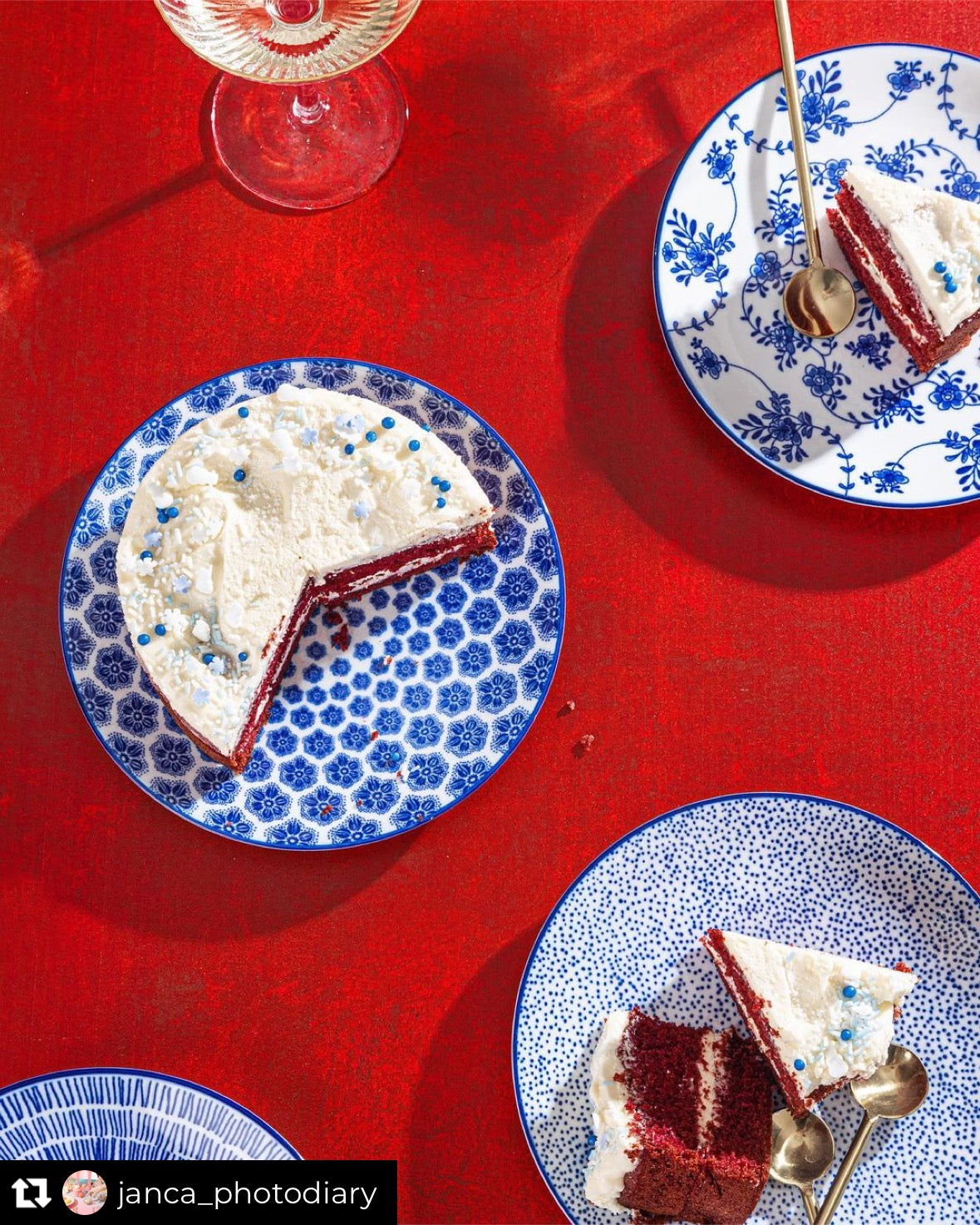 blue patterned plates with red velvet cake on a red backdrop