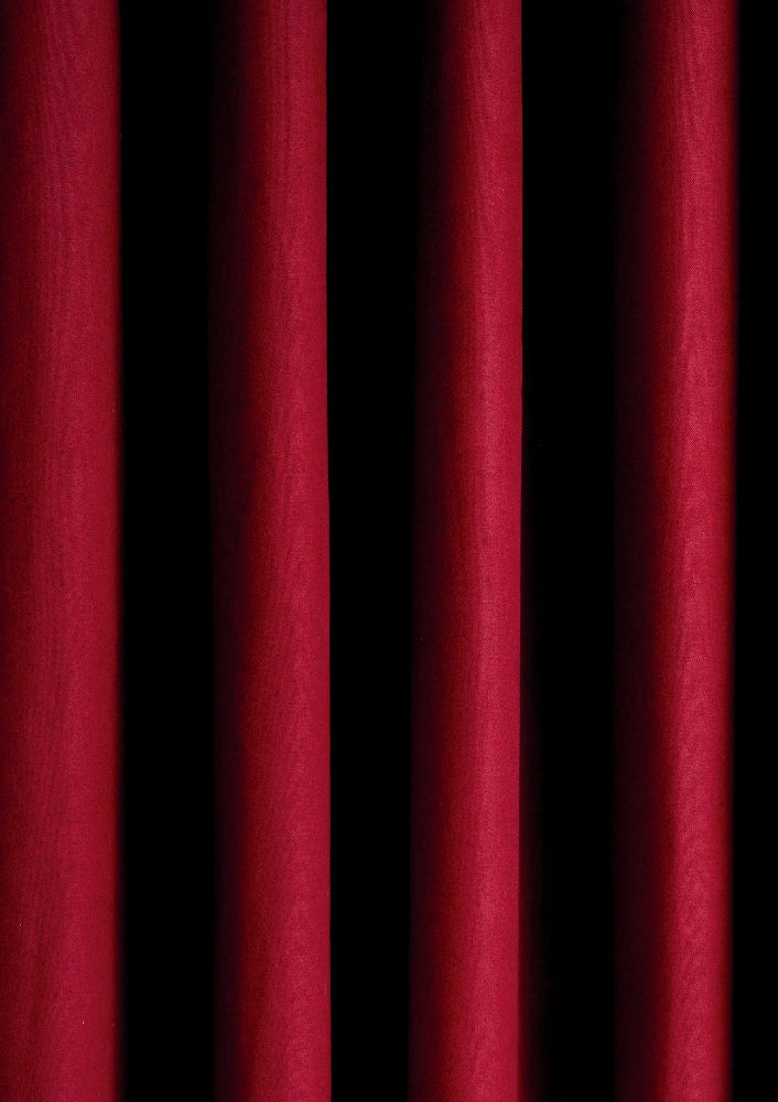 A close-up view of a red curtain effect photography backdrop with vertical folds creating a theatre-like ambiance.