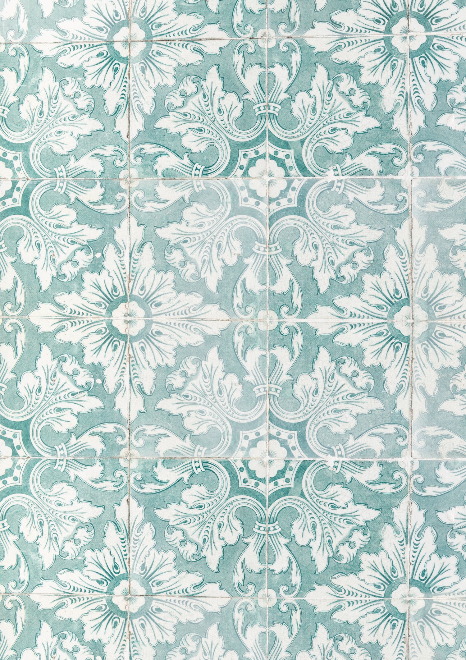 A close-up view of a soft jade green photography backdrop with a vintage Spanish tile pattern.