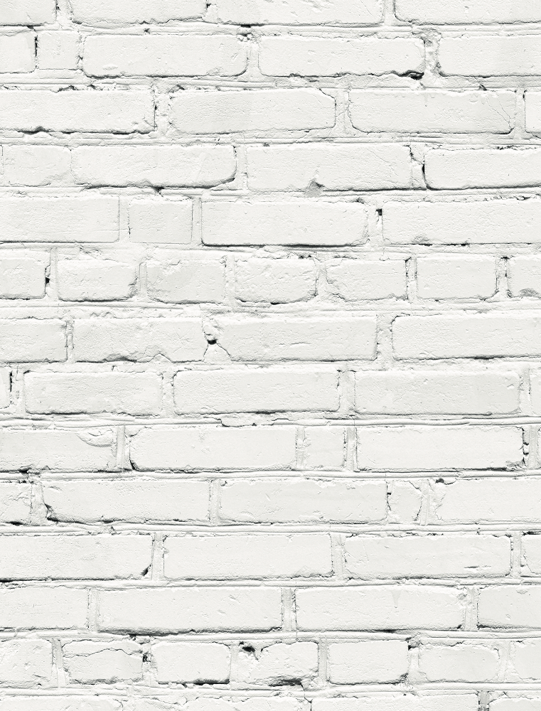 A close up of a white brick wall-effect vinyl photography backdrop with varying shades of grey and mortar lines designed to mimic a brick wall texture.