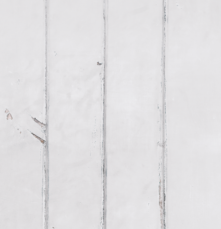 Close up of a white painted wood photography backdrop with vertical planks and natural wear showing beneath the paint.
