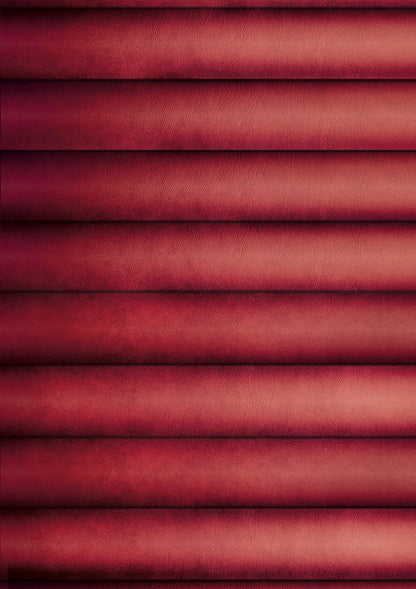 A close-up view of a red ribbed leather effect photography backdrop with highlights and shadows captured from an American diner upholstered booth.