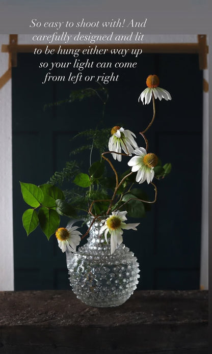 Clear glass vase with flowers on a dark background