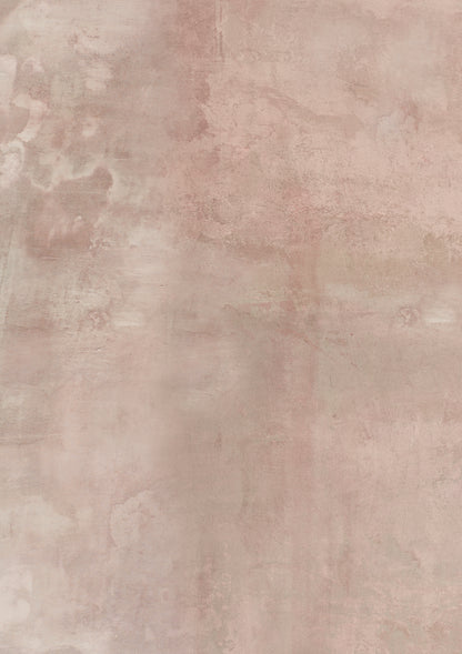 A close-up image of a beige-coloured vinyl photography backdrop captured from a bare plaster wall.