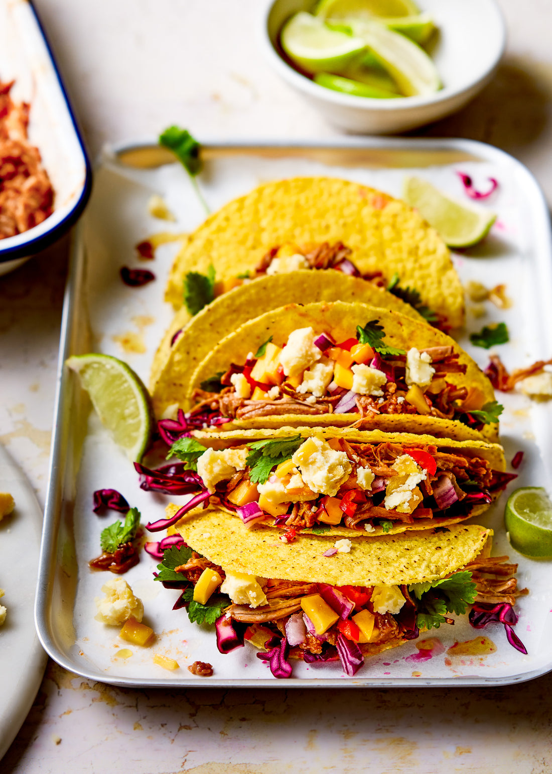 A colourful food photo of a tray of tacos styled on a crackled yellow paint effect photography backdrop ideal for food and product styling.