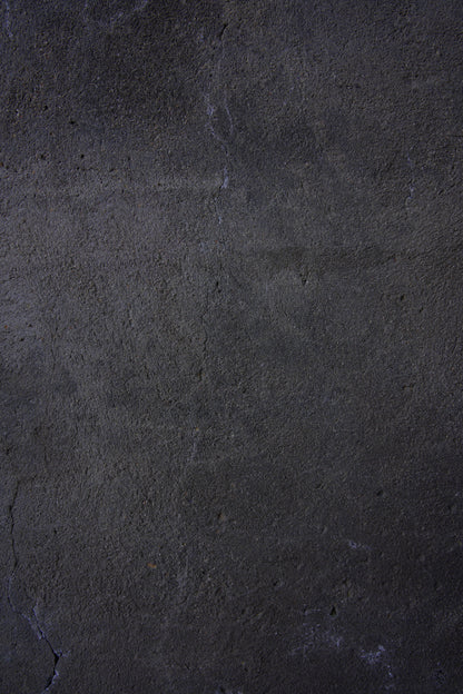 Dark textured vinyl photography backdrop captured from a weathered black plaster wall with subtle gray undertones and fine cracks.