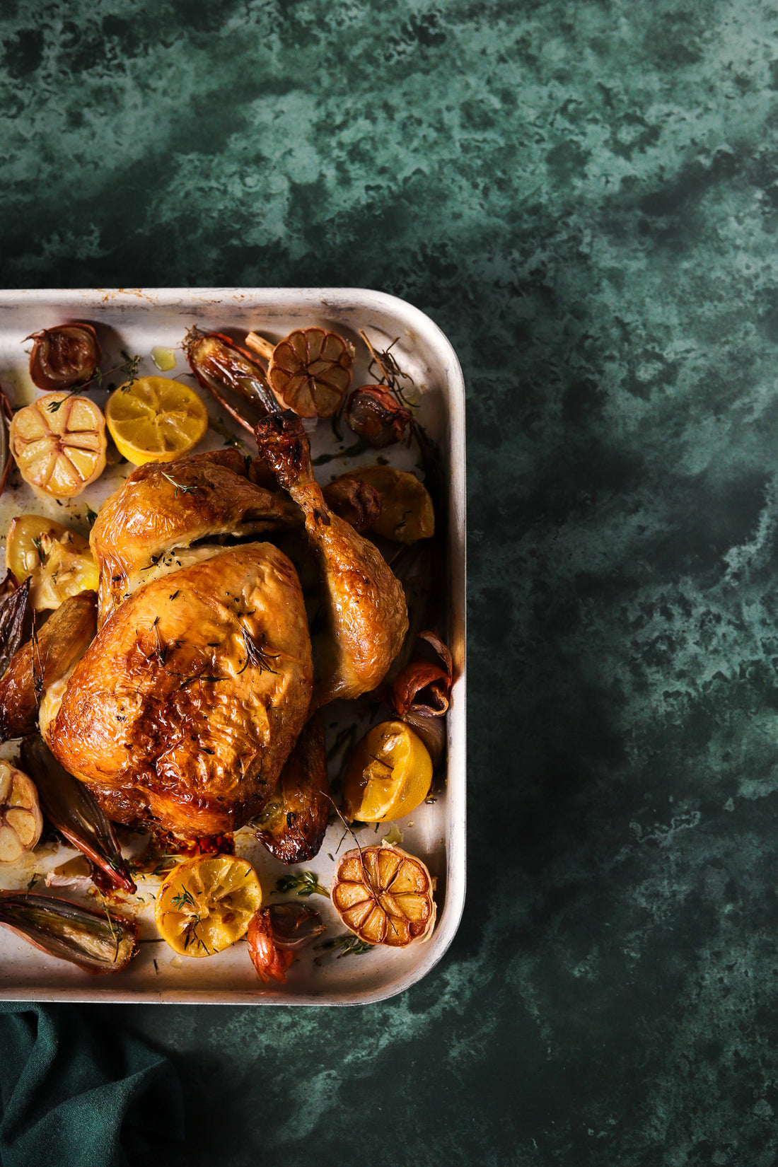 Dark green marble photography backdrop with roast chicken tray
