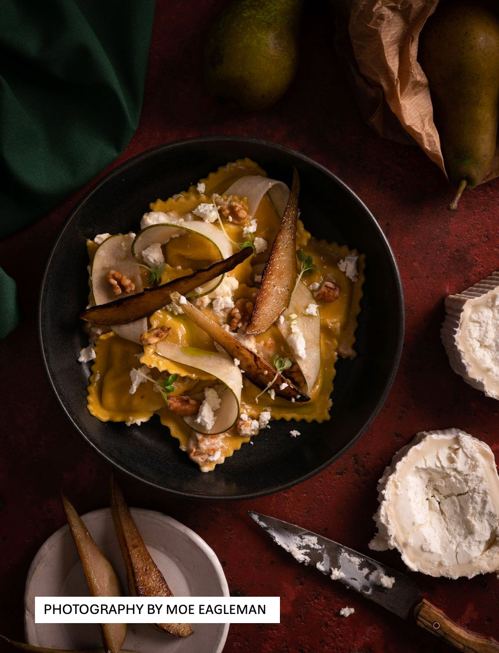 Flat lay shot of a bowl of ravioli styled on a highly textured rusty red metal effect photography backdrop used for food and product styling.