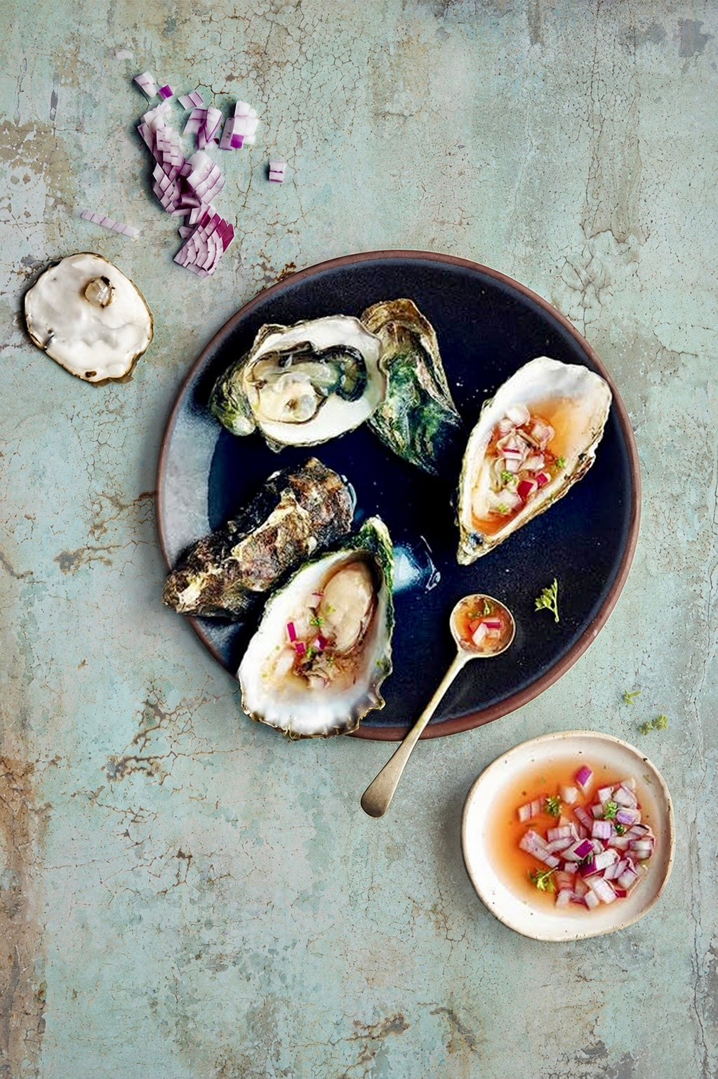 Plated oysters with garnishes on a textured surface