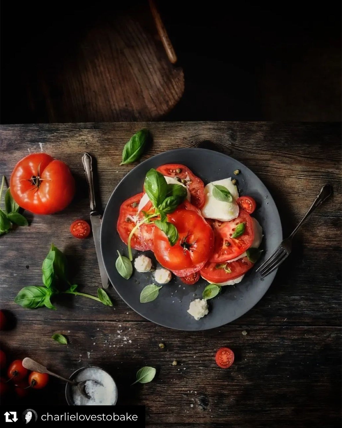 A dark, old wood effect vinyl photography backdrop with visible grain and natural patterns, styled with a plate of tomatoes and basil