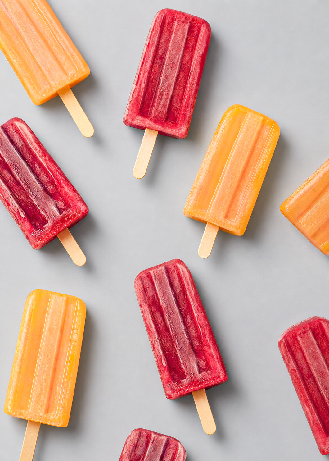 Colorful popsicles arranged on a gray background