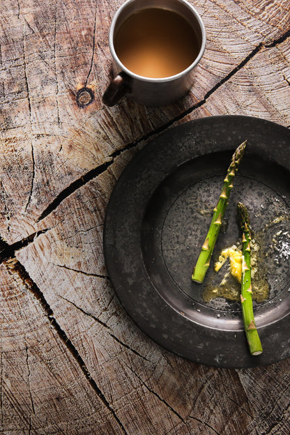 Mug of tea and old vintage plate with two pieces of asparagus on a
vinyl photography backdrop depicting a close-up view of a cut tree log with visible wood rings and textures.