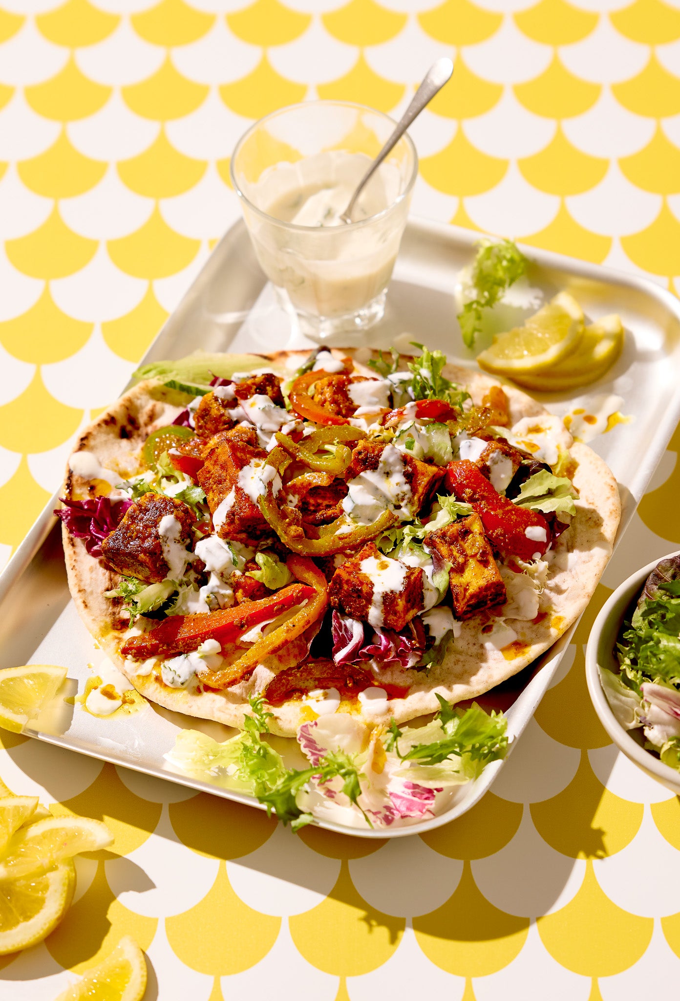 A brightly lit Mexican wrap styled on a scalloped yellow and white tile effect graphic photography backdrop.