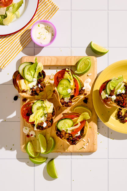 A flat lay of Mexican fast food styled on a white tile-effect vinyl photography backdrop with grid lines.