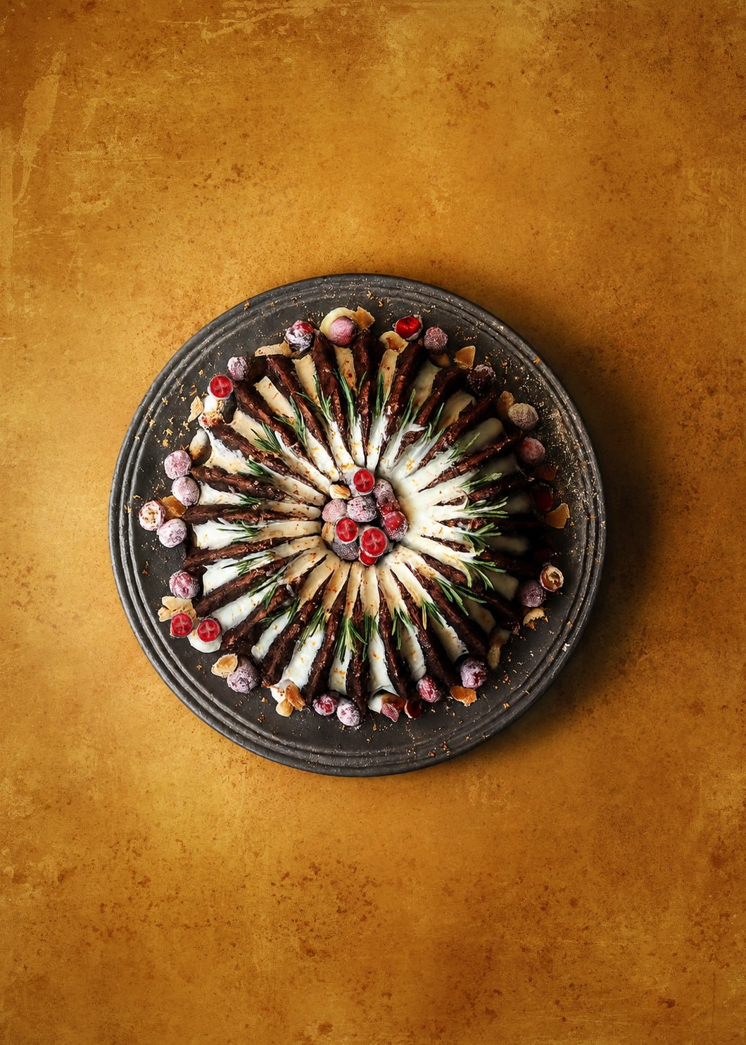 Decorative plate with a circular arrangement of colourful bundt cake on a golden mottled background