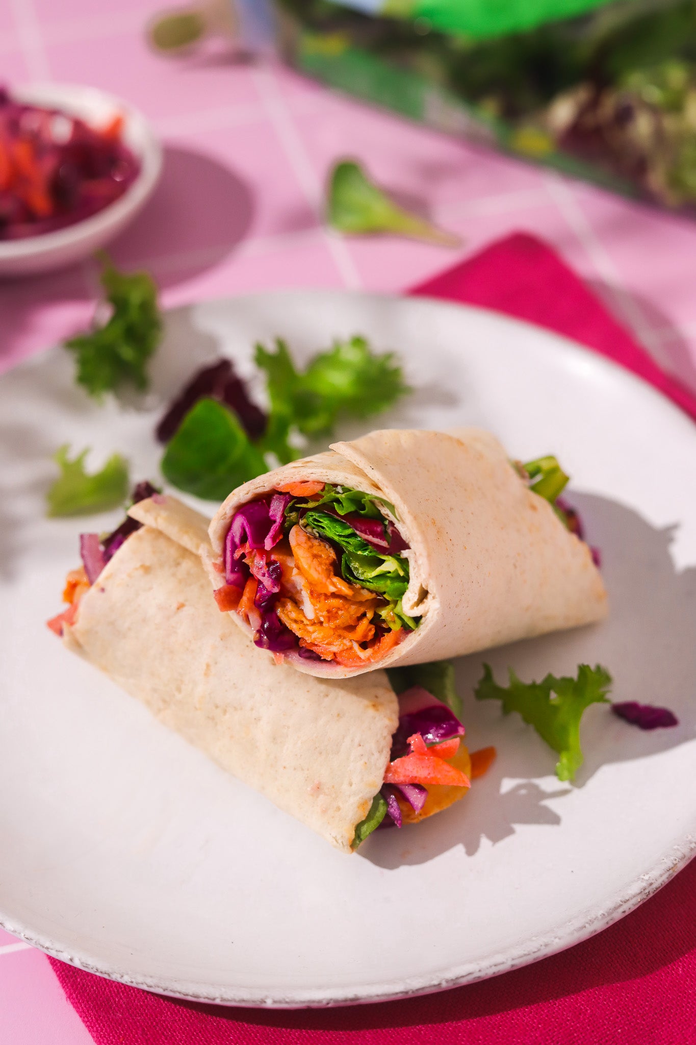 Close up of a colourful salad wrap shot on a pink tile graphic effect vinyl photography backdrop for food and product styling.
