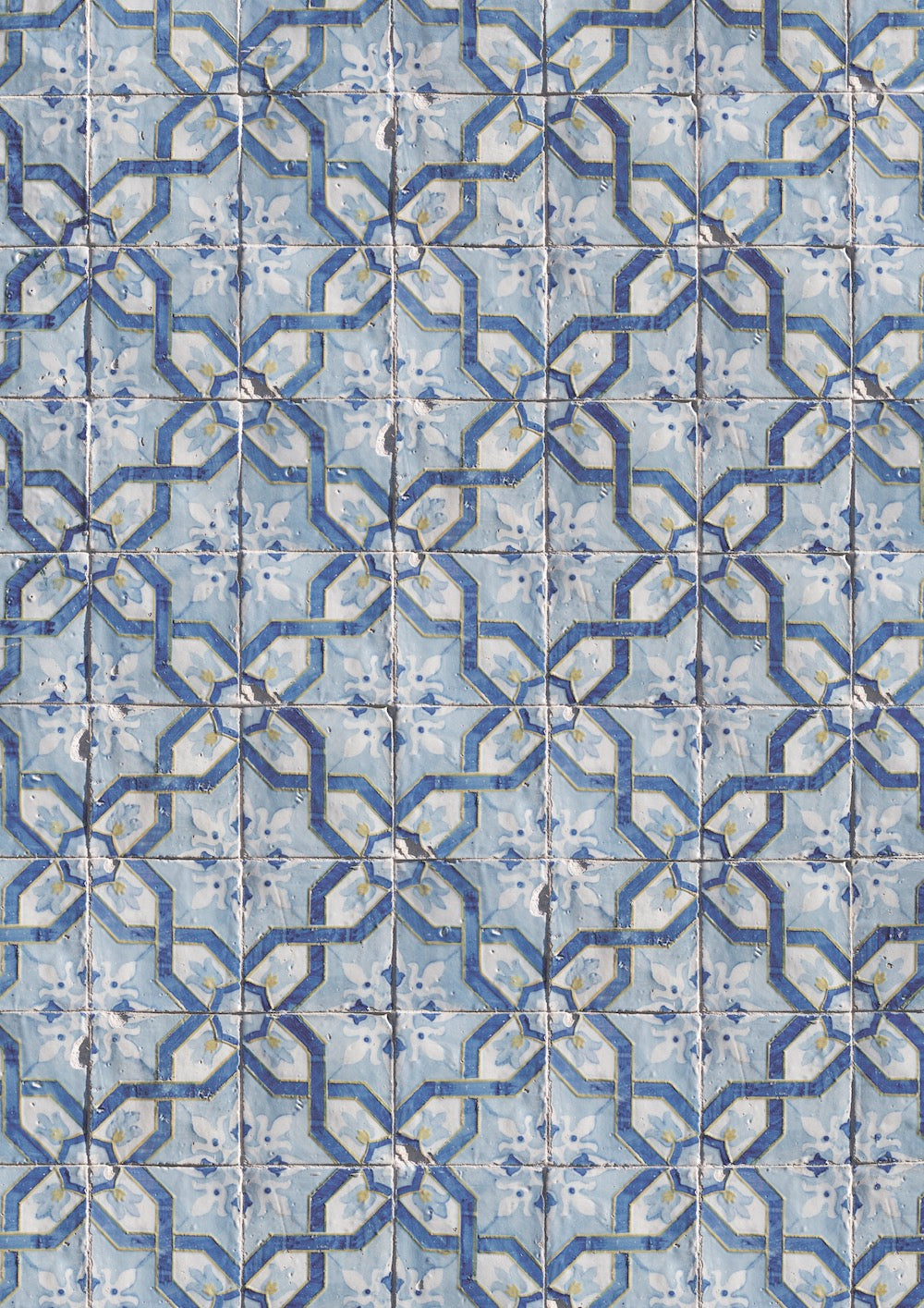 A close-up view of a photography backdrop featuring a Portuguese geometric tile pattern in blue, white, and yellow.