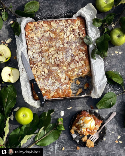 A flat lay of an apple pie styled on a grungy grey-black vinyl photography backdrop.