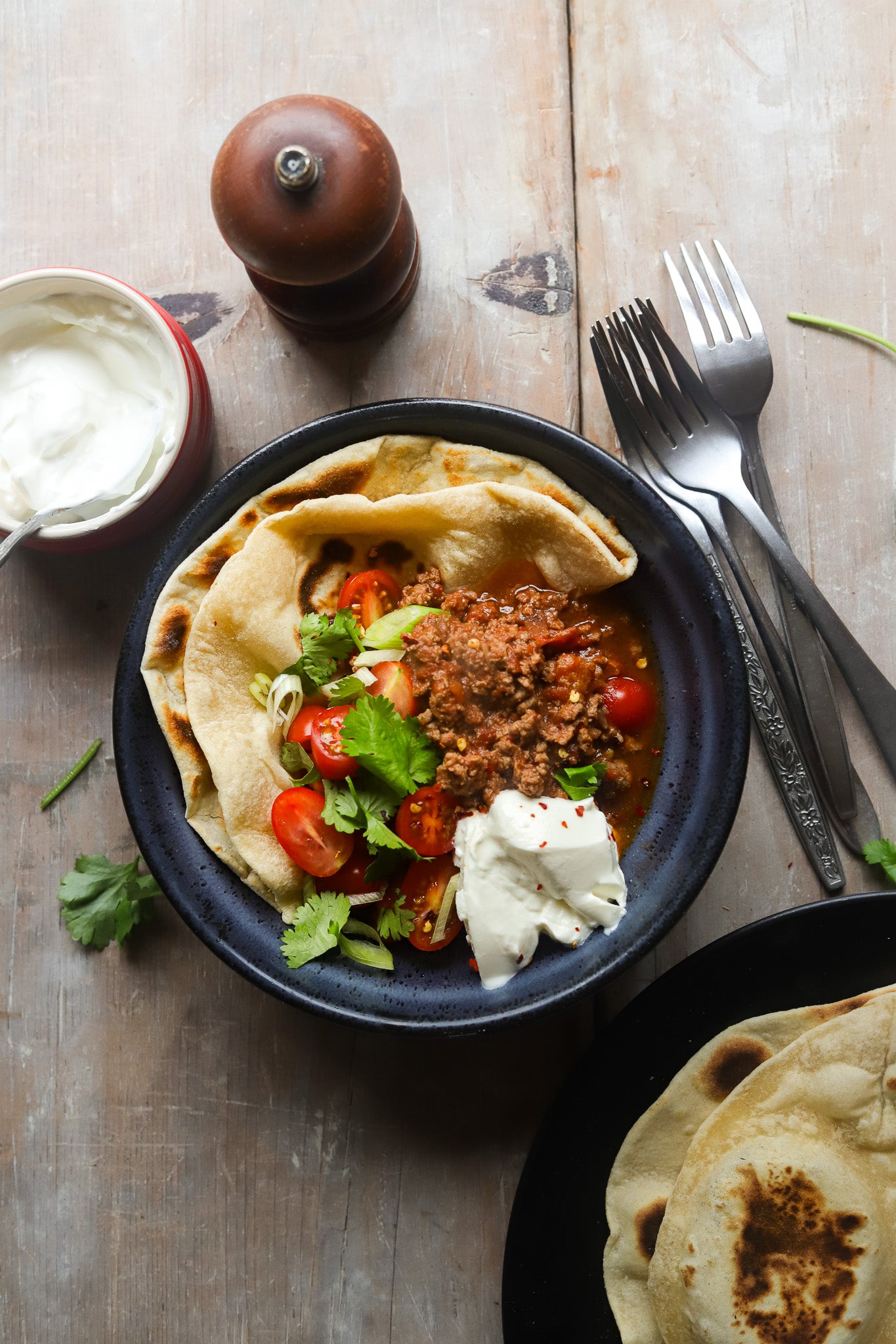 Bowl chilli con carne styled on a rustic vinyl photography backdrop captured from an antique wood board with visible wood grain, knots and cracks.