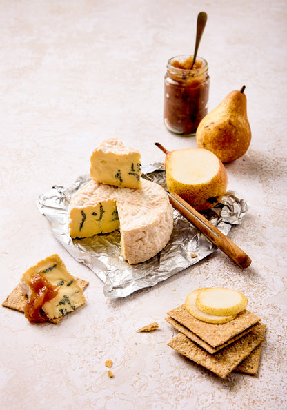 A cheese and chutney spread styled on a crackled cream paint effect vinyl photography backdrop.