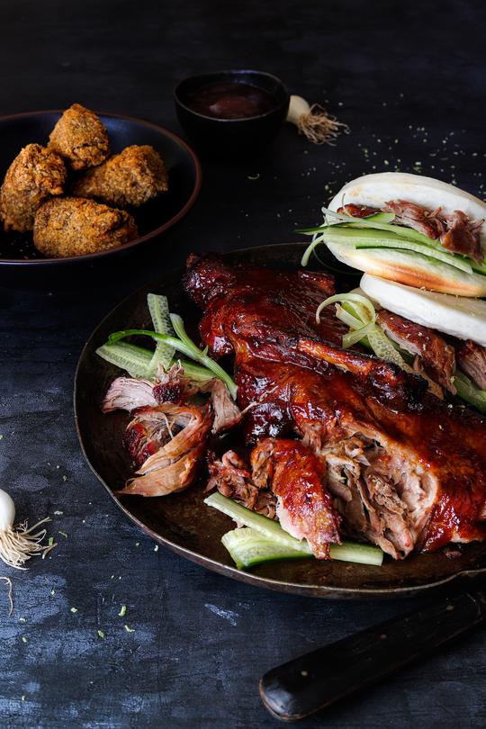 A close-up image of a Peking Duck food  photo styled on a vinyl photography backdrop showing a subtle, deep steely blue grey colour.