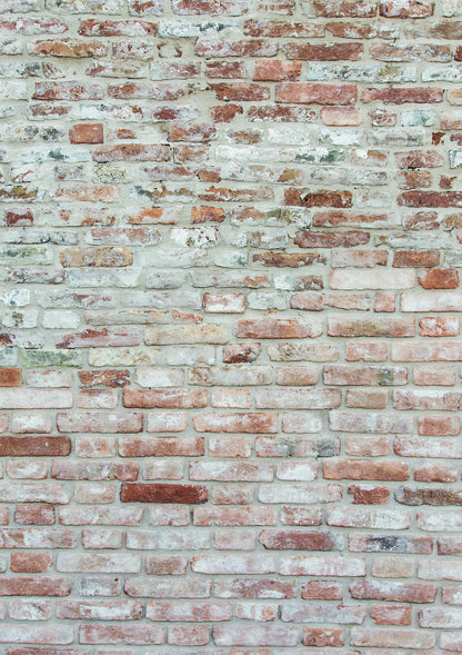 A close-up of a vinyl photography backdrop in a mix of red, grey, and white colors, simulating a rough brick wall texture.
