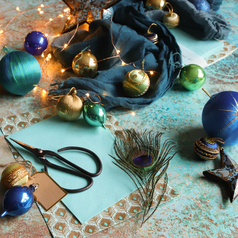 A textured product photography backdrop with a copper patina print, featuring hues of turquoise and rust, styled with Christmas baubles.