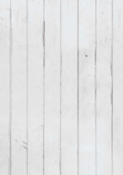 A white painted wood photography backdrop with vertical planks displaying natural wear and tear beneath the paint.