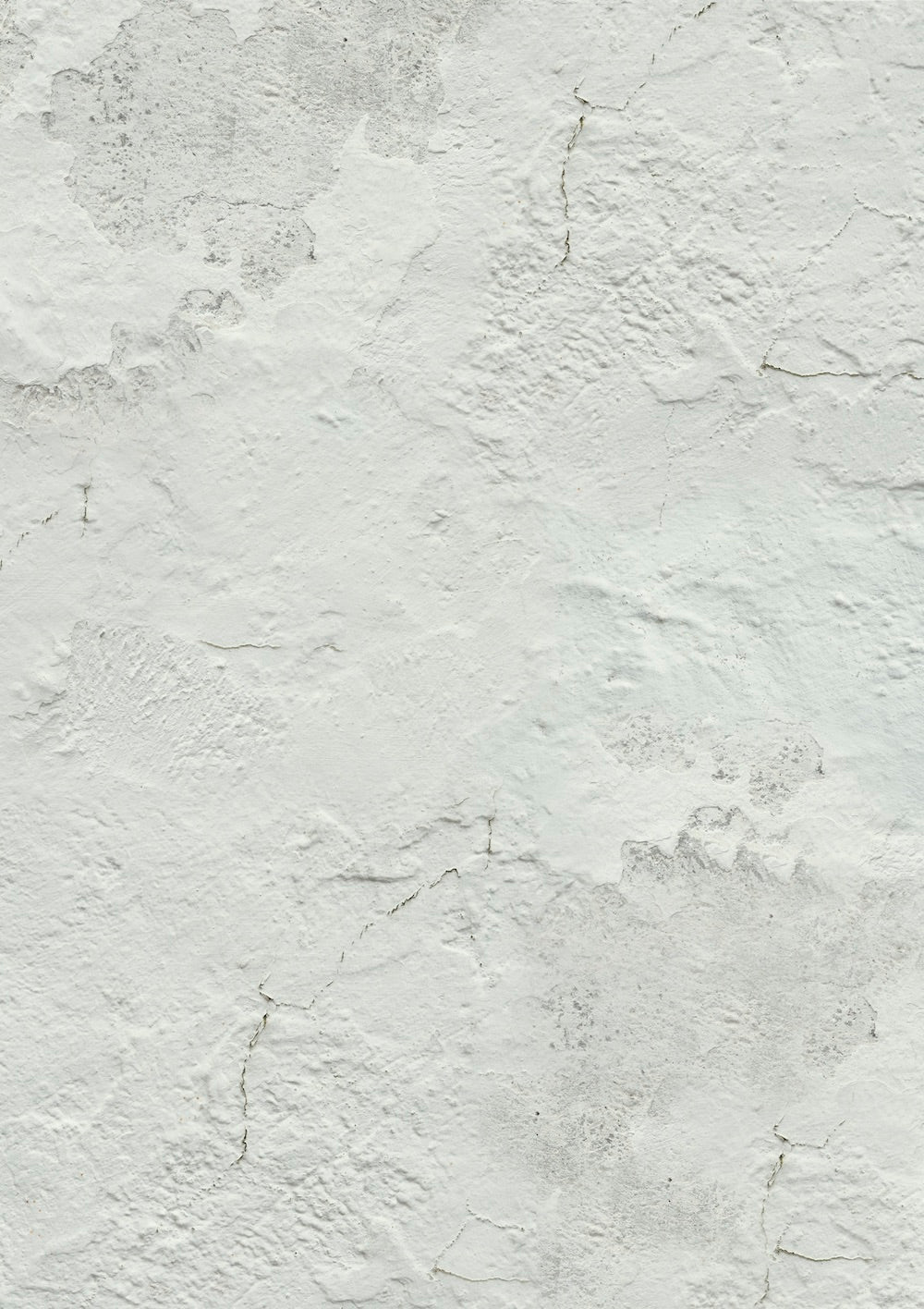 A close-up image of a white photography backdrop with subtle plaster texture details and slight grey tones.