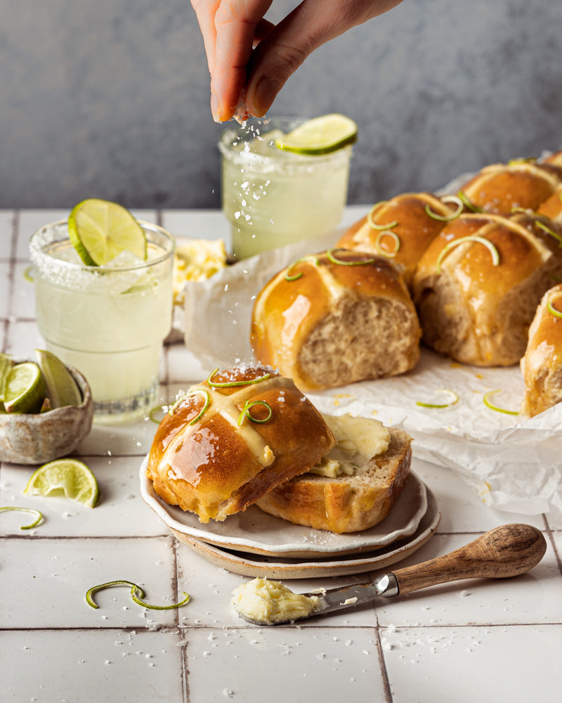 Margarita Hot Cross Buns styled on a white tile effect photography backdrop with a subtle gray grid lines texture.