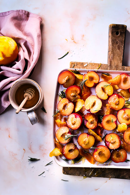 A soft peach marble photography backdrop with organic swirling patterns styled with a flat lay of roasted nectarines
