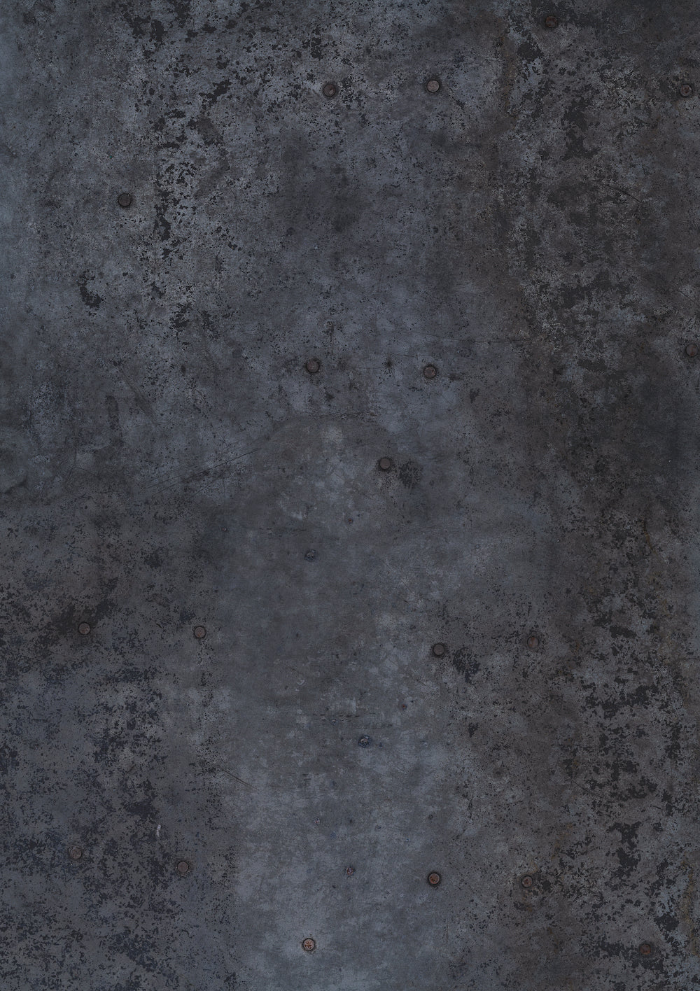 A dark grey metal patina effect photography backdrop with a textured surface featuring original circular rivets.