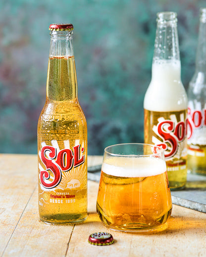 A food styling image of Sol beers on a green mottled vinyl photography backdrop
