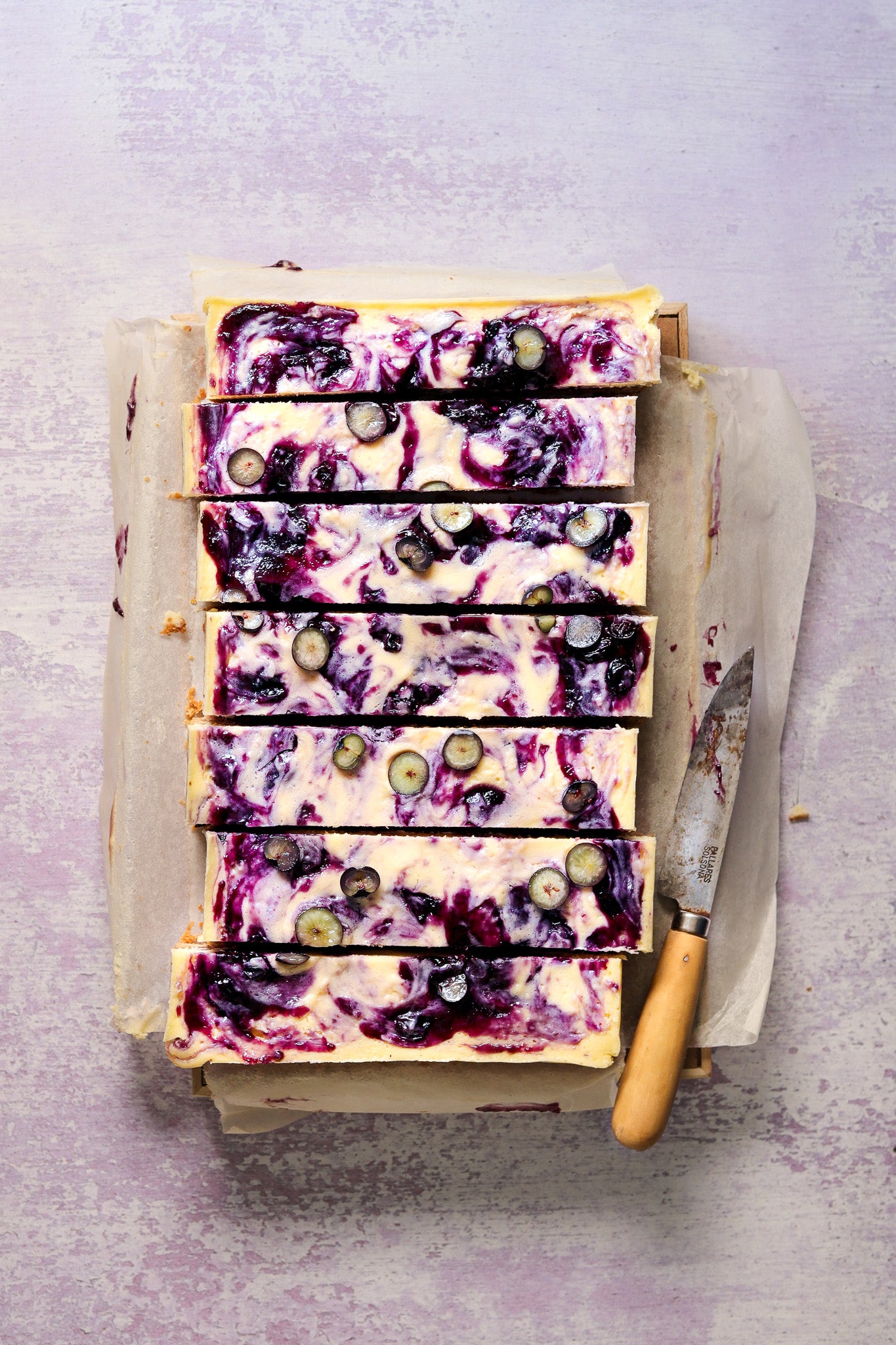 Flat lay of handmade cheesecake on a  textured light purple paint effect photography backdrop